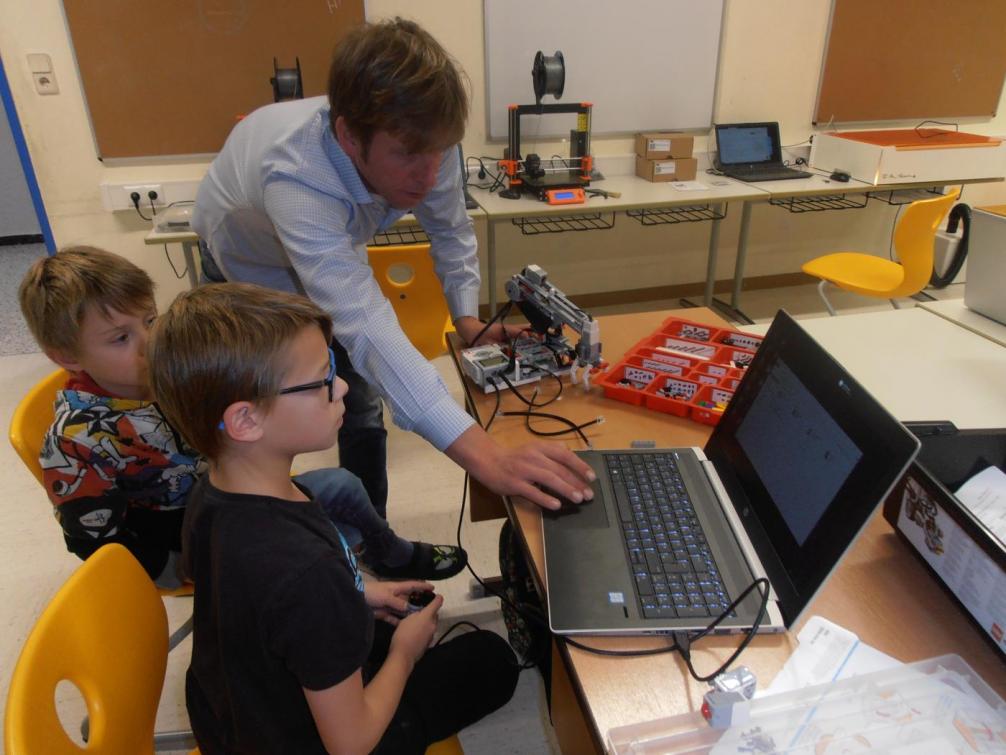 Schüler programmieren mit Hilfe des Lehrers Lego-Roboter